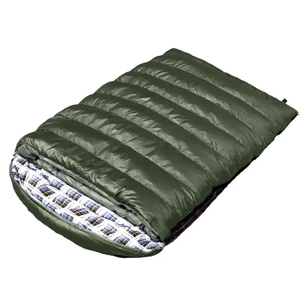 Two adults resting comfortably inside a large double sleeping bag outdoors at night.