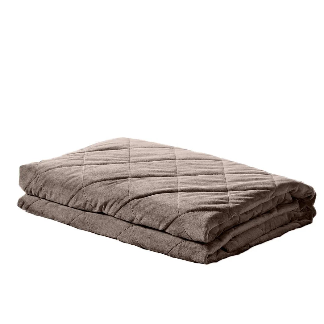 Mink color DreamZ 5KG weighted blanket neatly folded on a wooden bench in a cozy indoor setting.