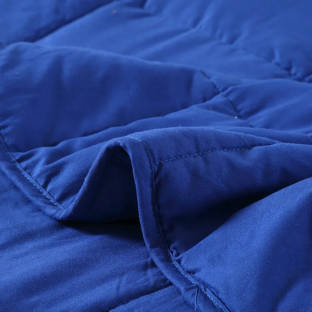 Person holding and feeling the soft navy weighted blanket fabric in hand.
