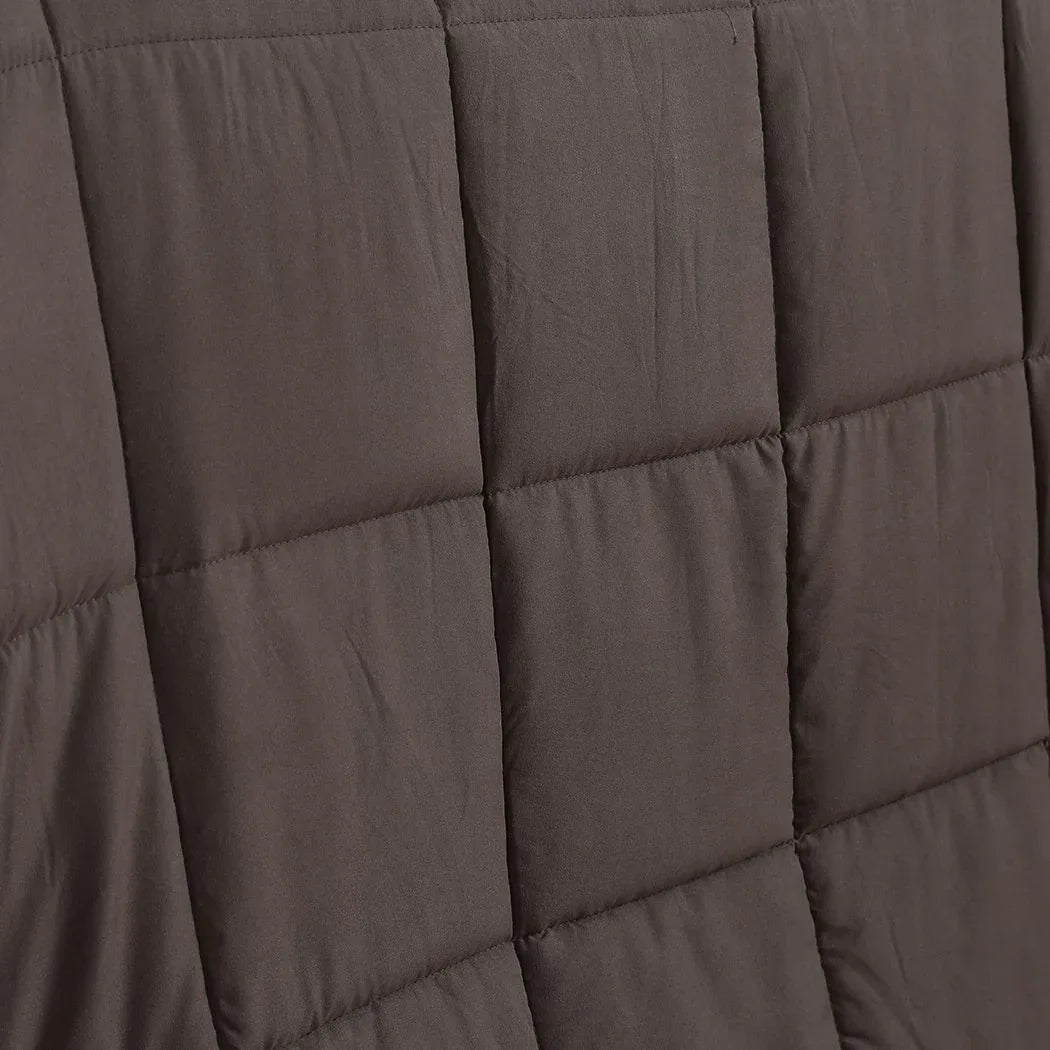 Hand pressing the plush surface of the DreamZ heavy weighted blanket showing softness.