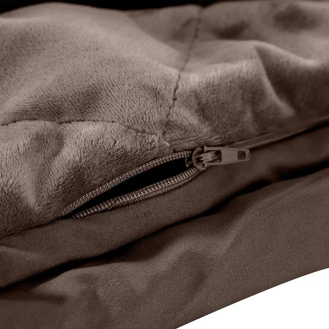 Soft mink colored weighted blanket draped over chair in minimalist styled bedroom corner.