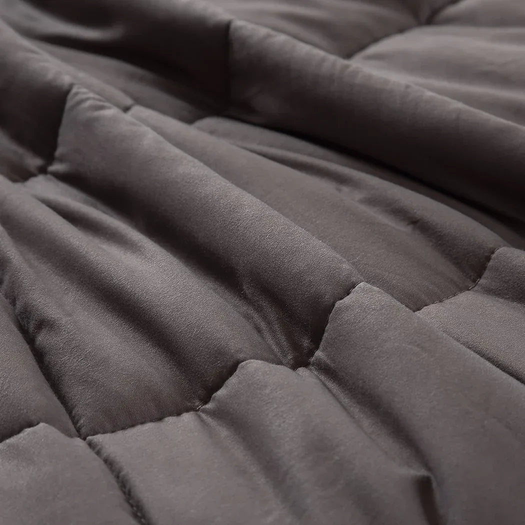 Grey weighted blanket lying on sofa, illustrating home comfort use.