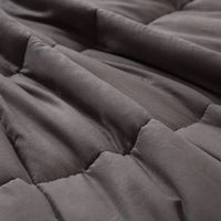 Grey weighted blanket lying on sofa, illustrating home comfort use.