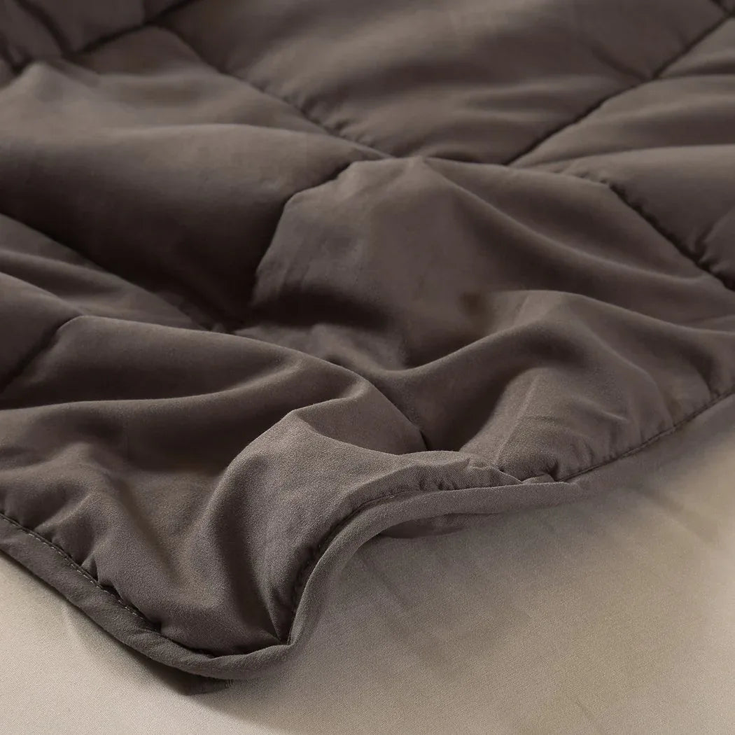 Weighted blanket placed on a bed with natural light showing its textured layering.