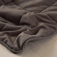 Weighted blanket placed on a bed with natural light showing its textured layering.