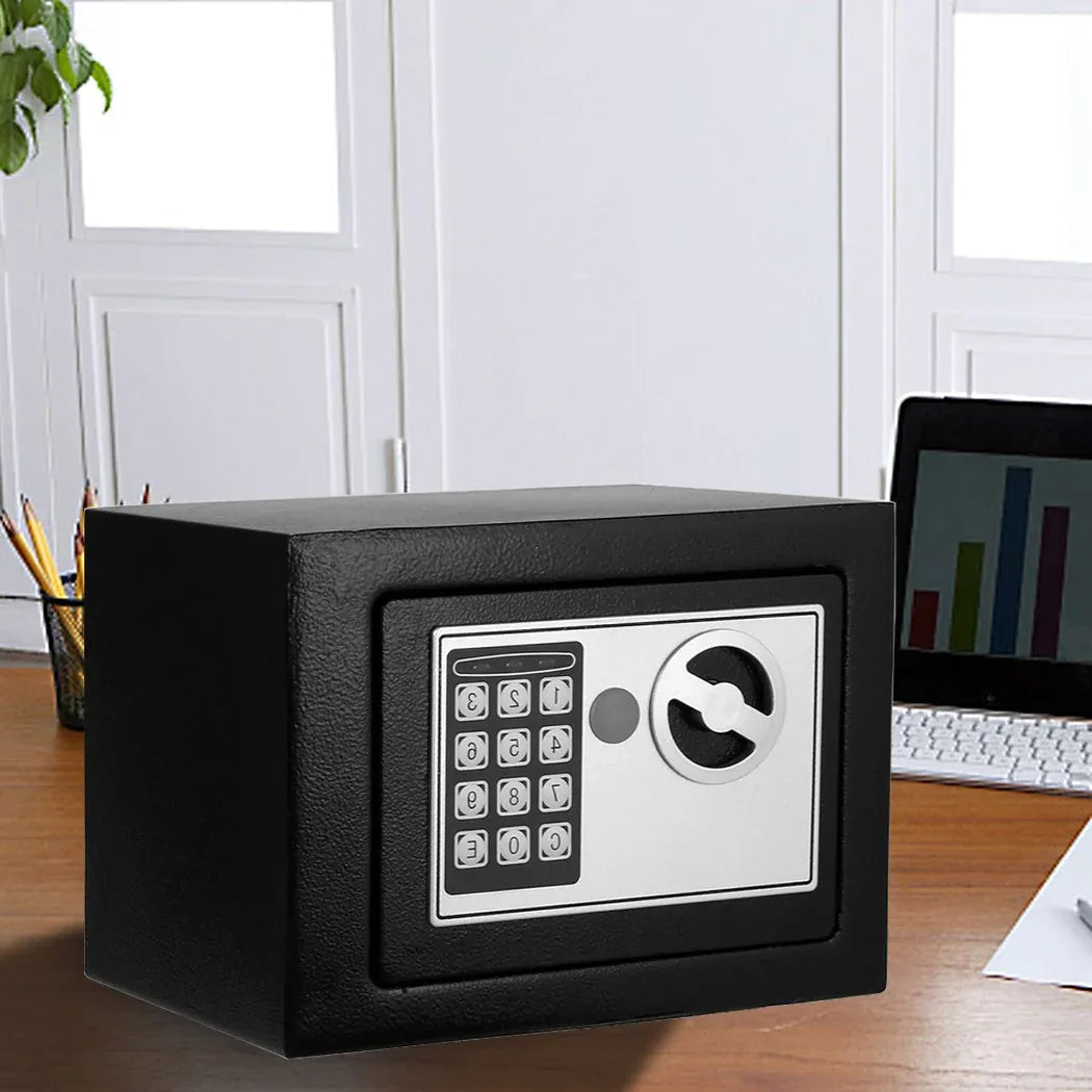 Electronic safe placed on office desk next to keyboard and documents for security.
