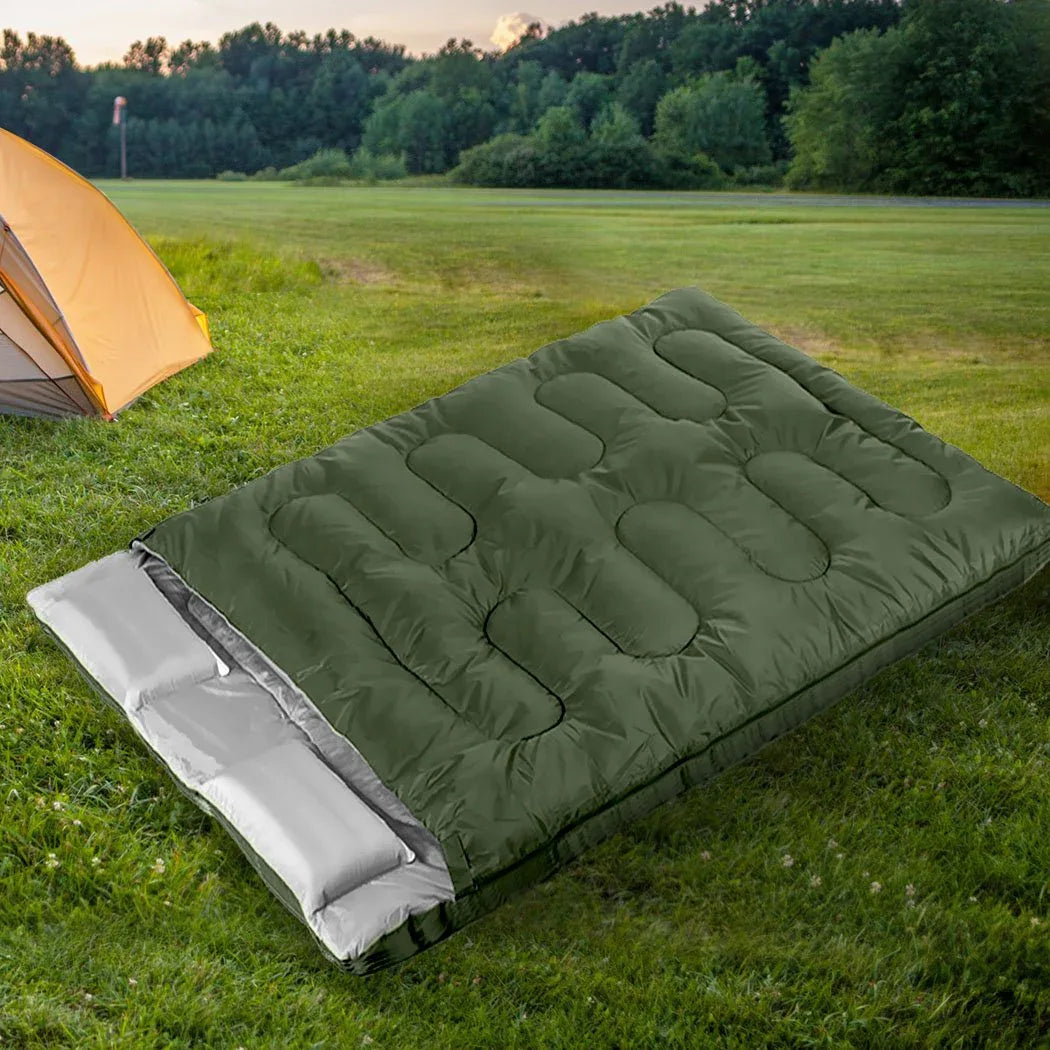 Sleeping bag placed on grassy outdoor spot with trees in soft focus background