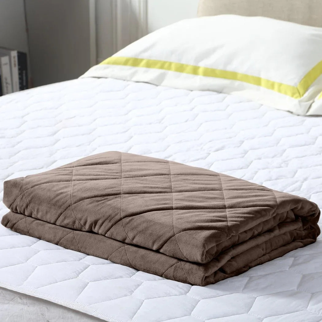 DreamZ weighted blanket folded on white bedding with soft natural light illuminating fabric texture.