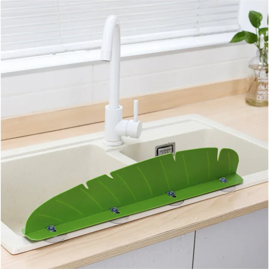 Close-up of yellow flexible kitchen sink splash guard suction cups securing it to the sink.