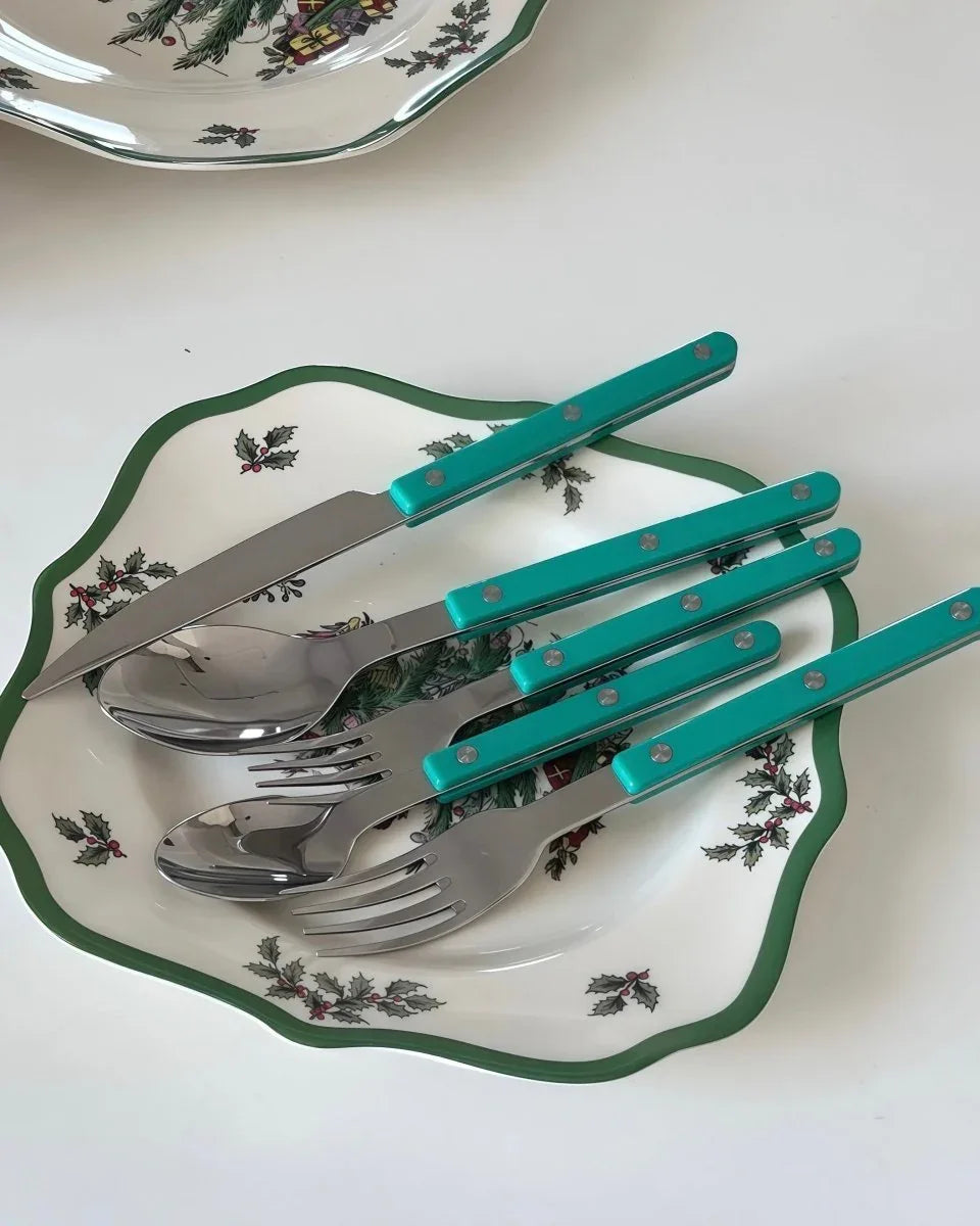 Turquoise flatware set including spoons, forks, and knives displayed on a white background.