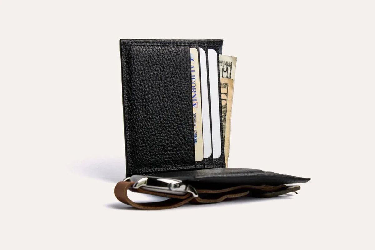 Classic leather wallet flat on white background, showing pebbled texture and contrast stitching.