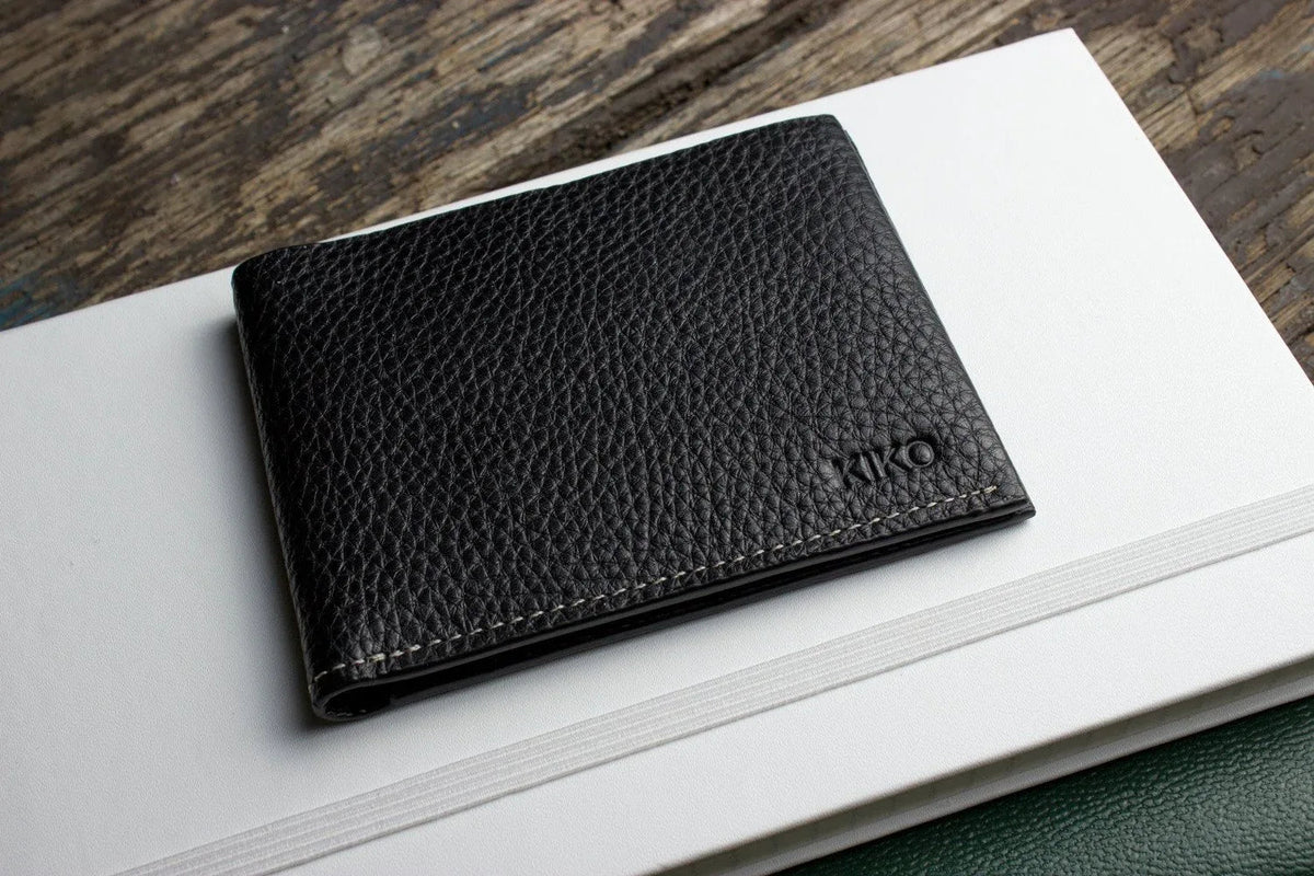 Black leather wallet fully opened to show organizational features and craftsmanship.