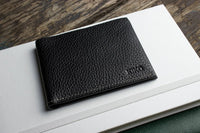 Black leather wallet fully opened to show organizational features and craftsmanship.