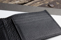 Black wallet interior with multiple compartments and self-lined bill section.