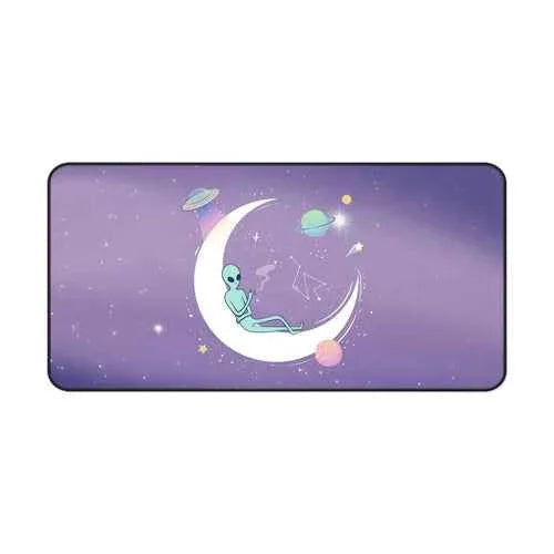 Wide angle showing full alien space-themed desk mat on dark surface