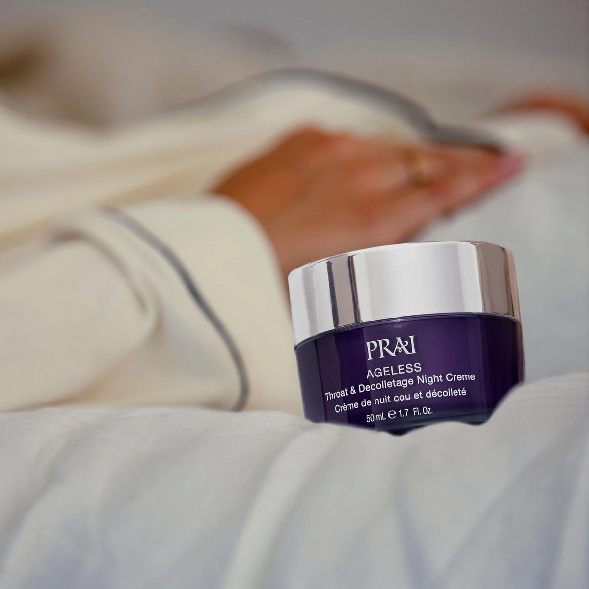 Smiling woman applying night cream on her throat and décolletage area