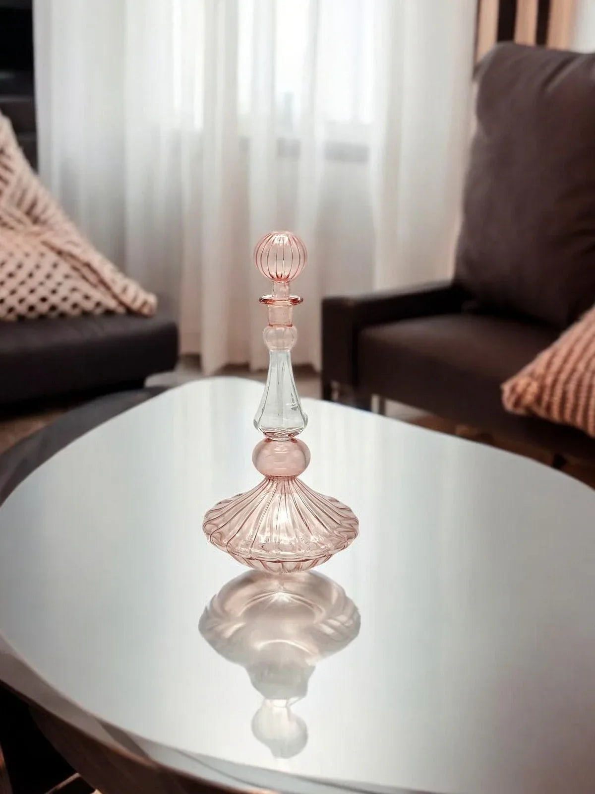 Intricate hand painted essential oil bottle made of hand blown clear glass with floral motifs.