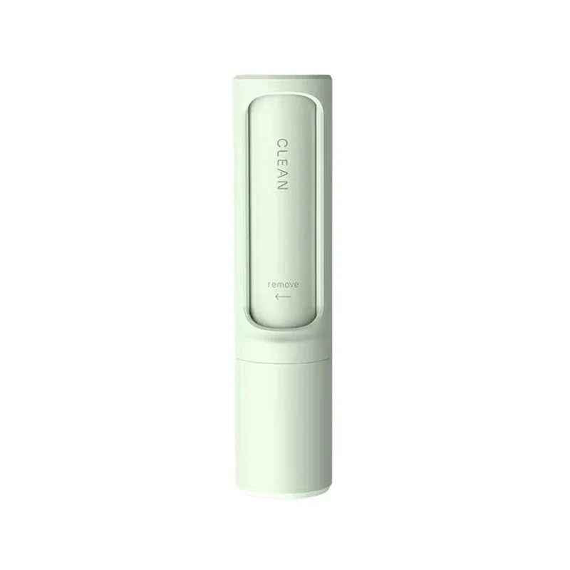 Hand pressing button on pet hair remover brush to empty collected fur from dustbin.