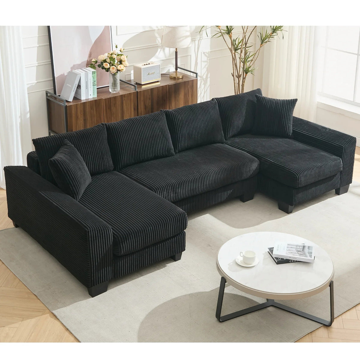 Large black U-shaped corduroy sleeper sofa with plush cushions, square arms, and pull-out bed extended.