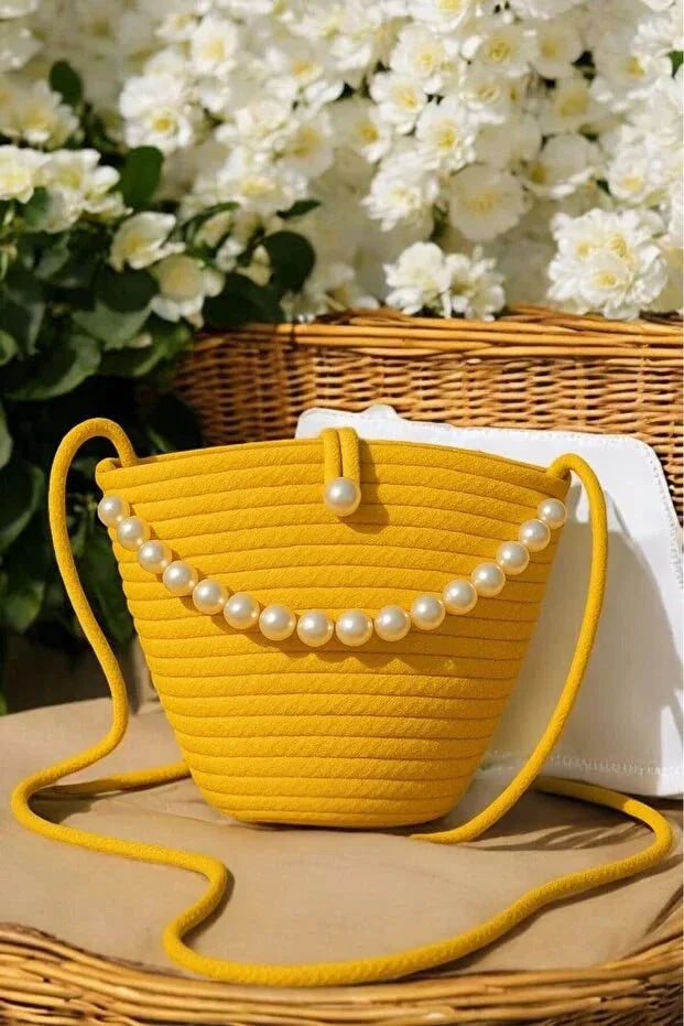 Yellow shoulder bag with pearl design detail, displayed on a white background