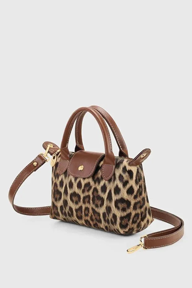 Side angle showing slim profile and strap of the black PU leather crossbody bag.