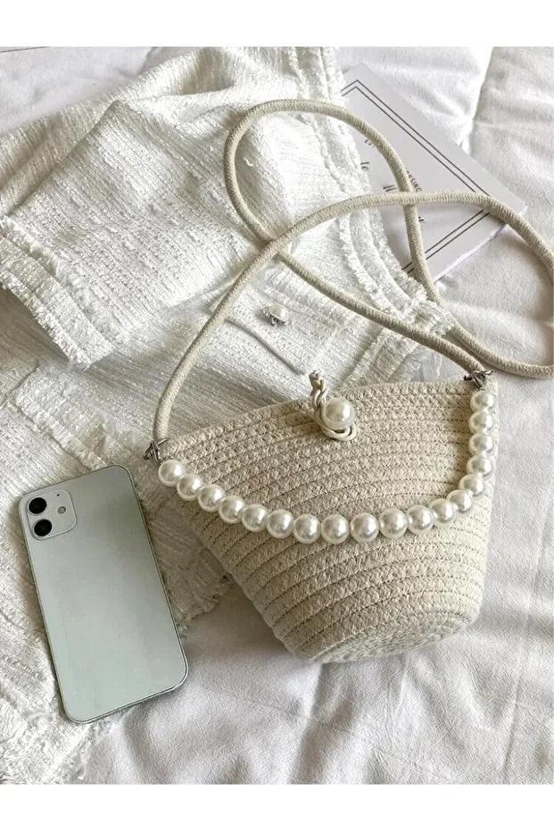 Side view of the off white shoulder bag showing its slim baguette shape and smooth finish.