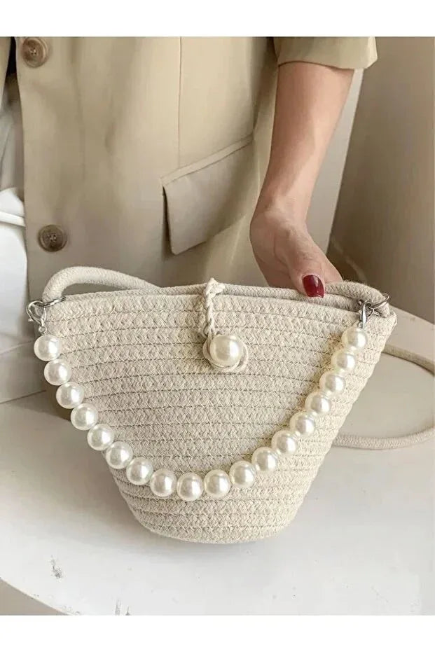Top view of the bag emphasizing its simple clasp and pearl embellishments on the strap.
