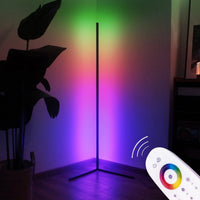 RGB LED corner floor lamp illuminated with soft, colorful light in a dim room setting.