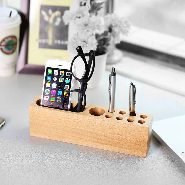 Wood phone holder with pen container, displaying a smartphone and several pens in a natural beech wood finish.