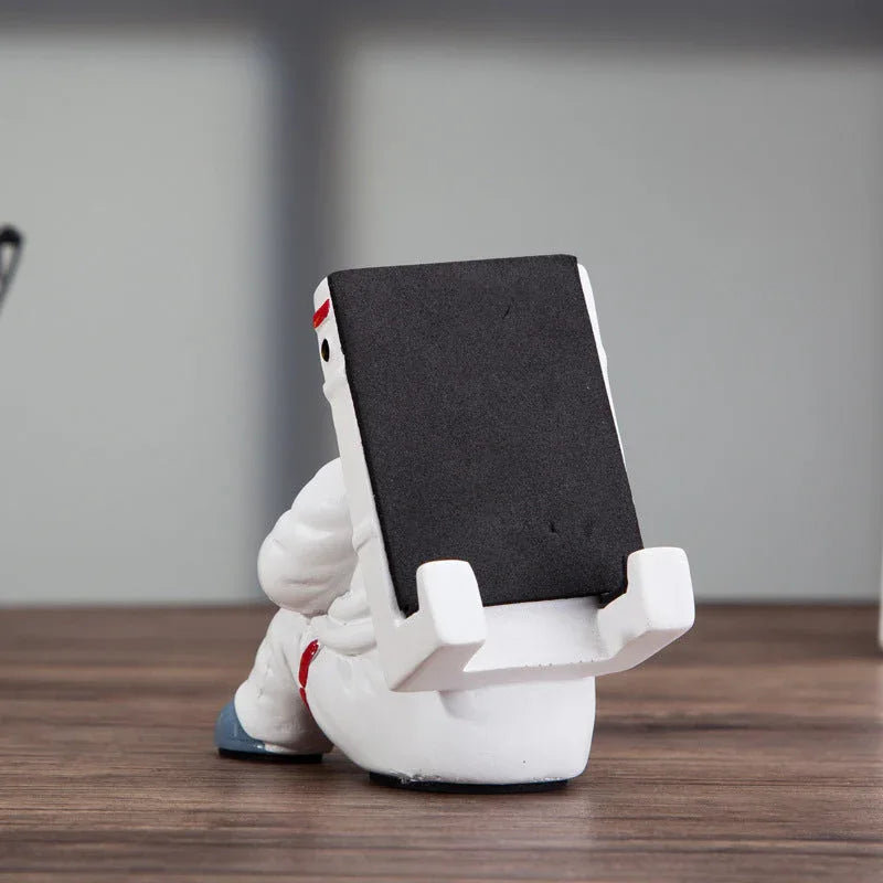 Side view of the astronaut phone stand showing detailed helmet and arms holding the phone.