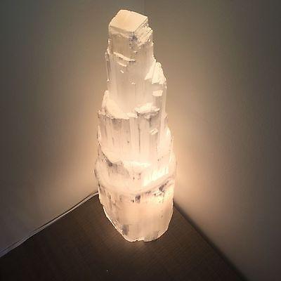 Close-up of translucent selenite crystal lamp showing natural striations and glowing softly.