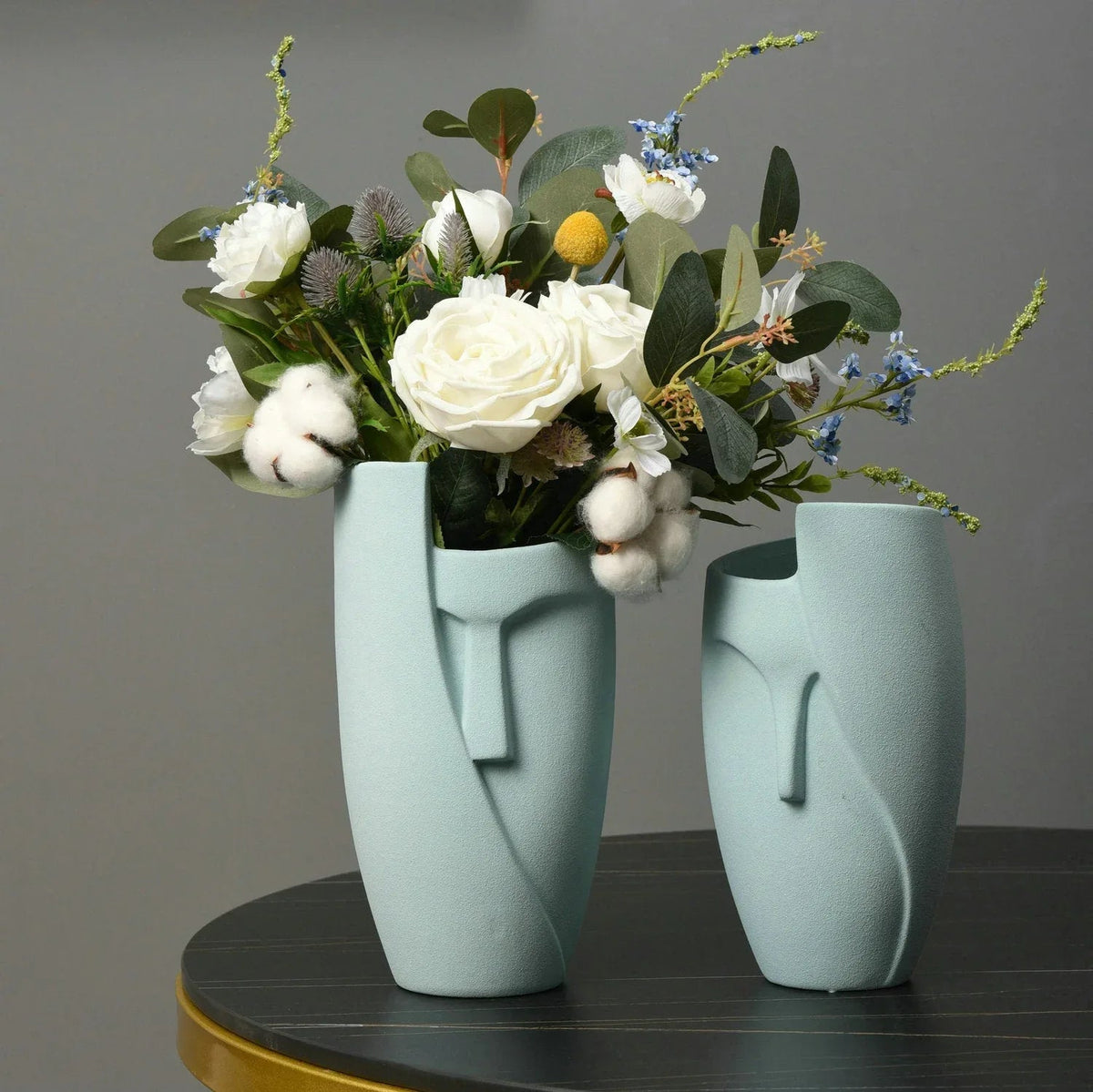 White ceramic face planter with green succulent plants, unique artistic design for indoor home decor.