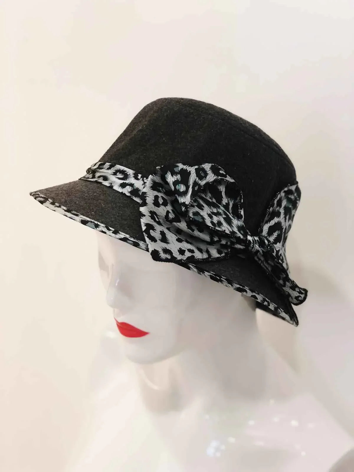 A soft bucket hat with a chic animal print, featuring a stylish bow tied at the side.