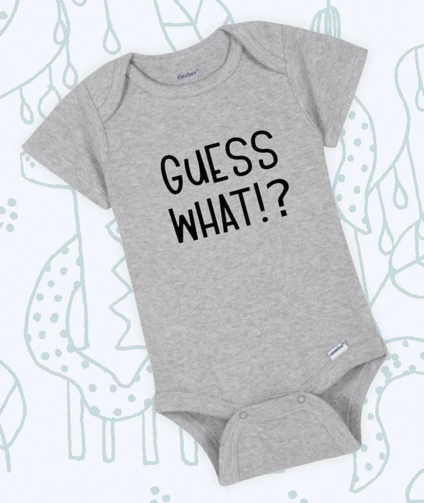 Baby wearing white onesie with playful 'Guess What!? Chicken Butt' text in colorful letters.