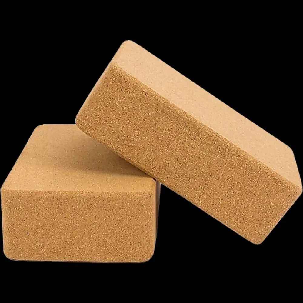 Two natural cork yoga blocks with rounded edges placed on a clean surface, ready for exercise or stretching.