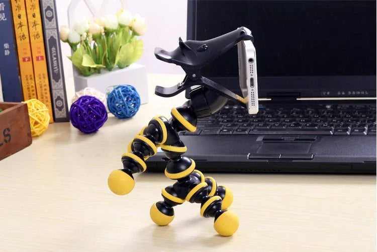 Two flexible animal phone stands side by side supporting smartphones on a light surface.