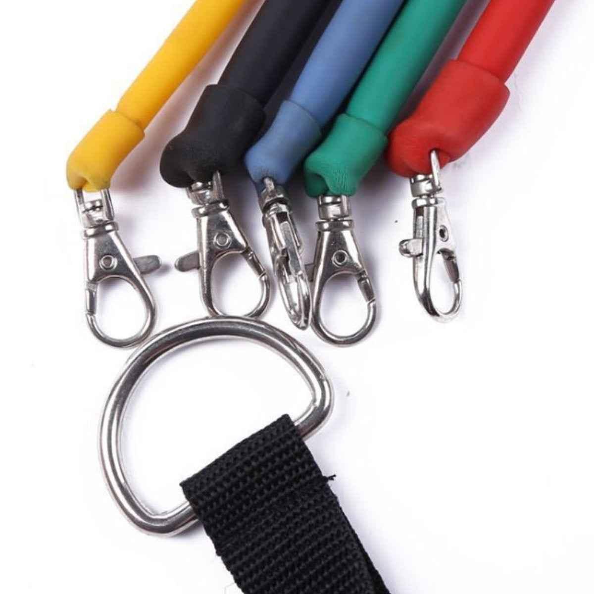 A set of colorful resistance bands with handles, ankle straps, and a door anchor laid out on a white background.