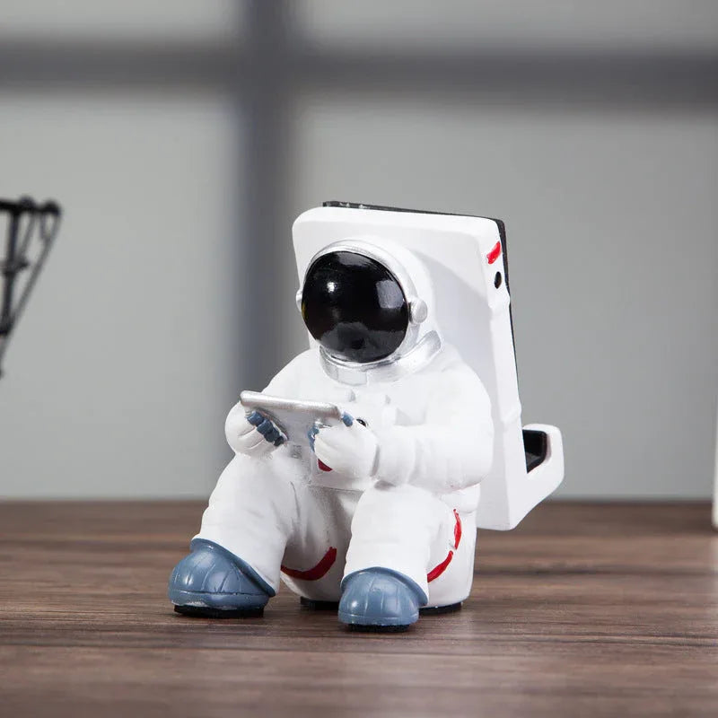 Astronaut mobile stand on a student desktop with books and stationery in the background.