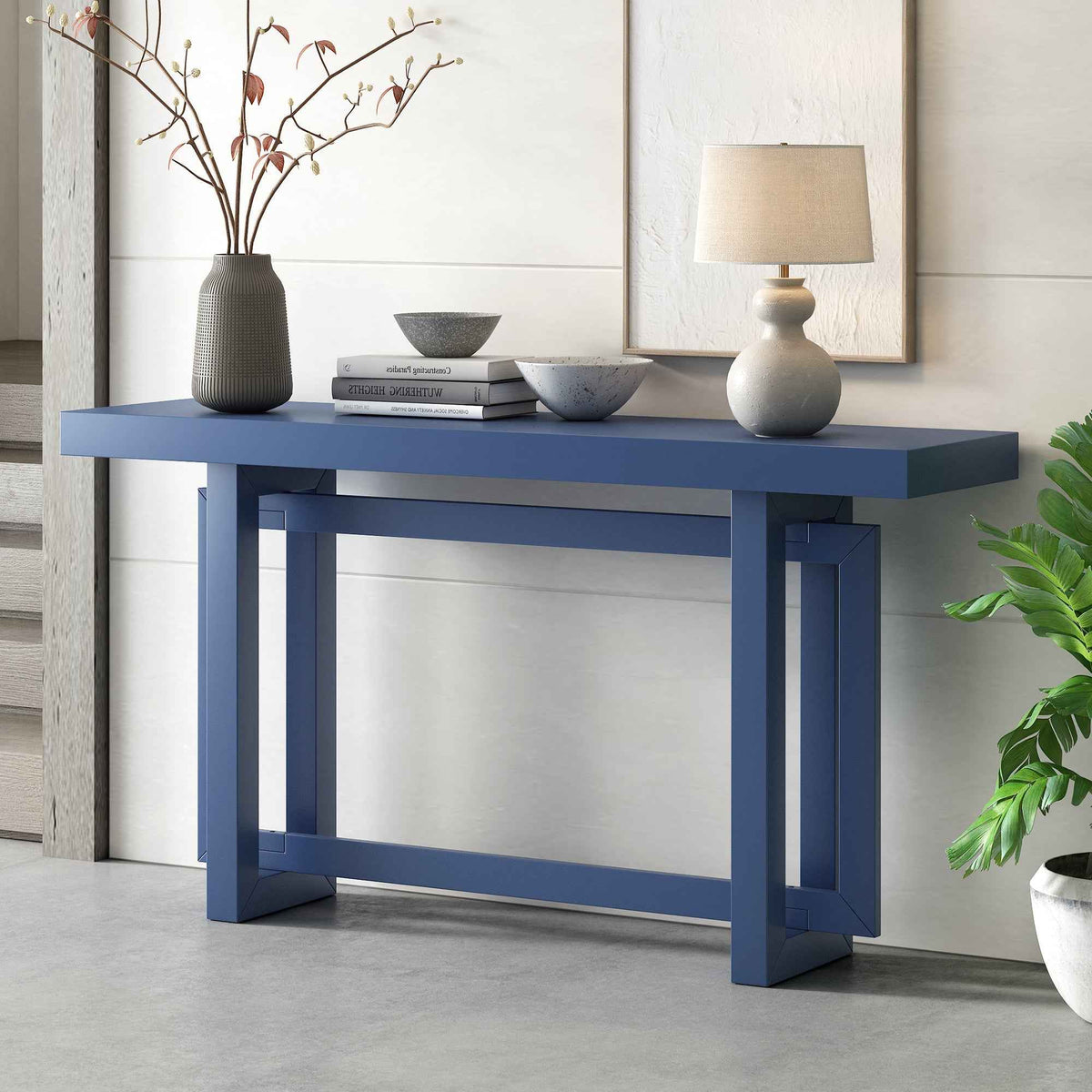 Console table with wood top in navy blue, styled with decor in a modern interior hallway.