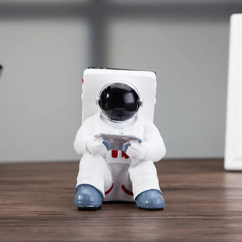 Back view of white astronaut mobile phone stand highlighting resin material texture.
