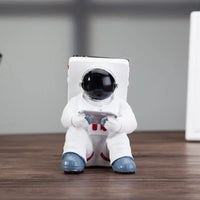Back view of white astronaut mobile phone stand highlighting resin material texture.