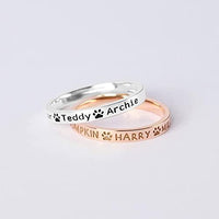 Close-up of sterling silver dog name ring with custom engraved pet names.