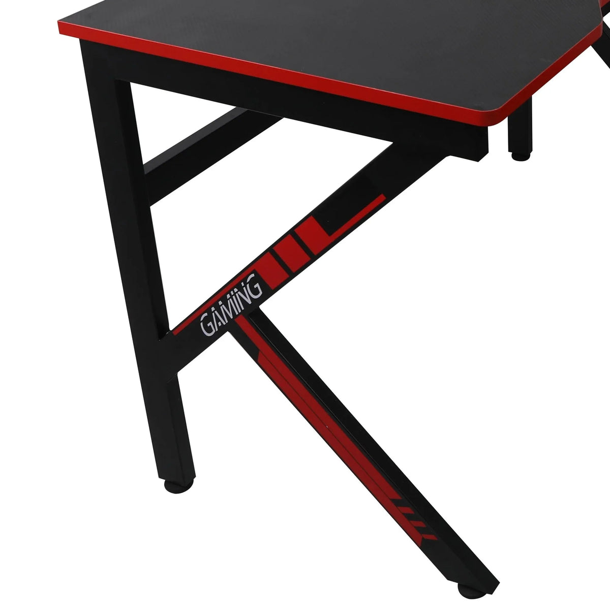 Person sitting at black gaming desk with multiple monitors and gaming accessories.