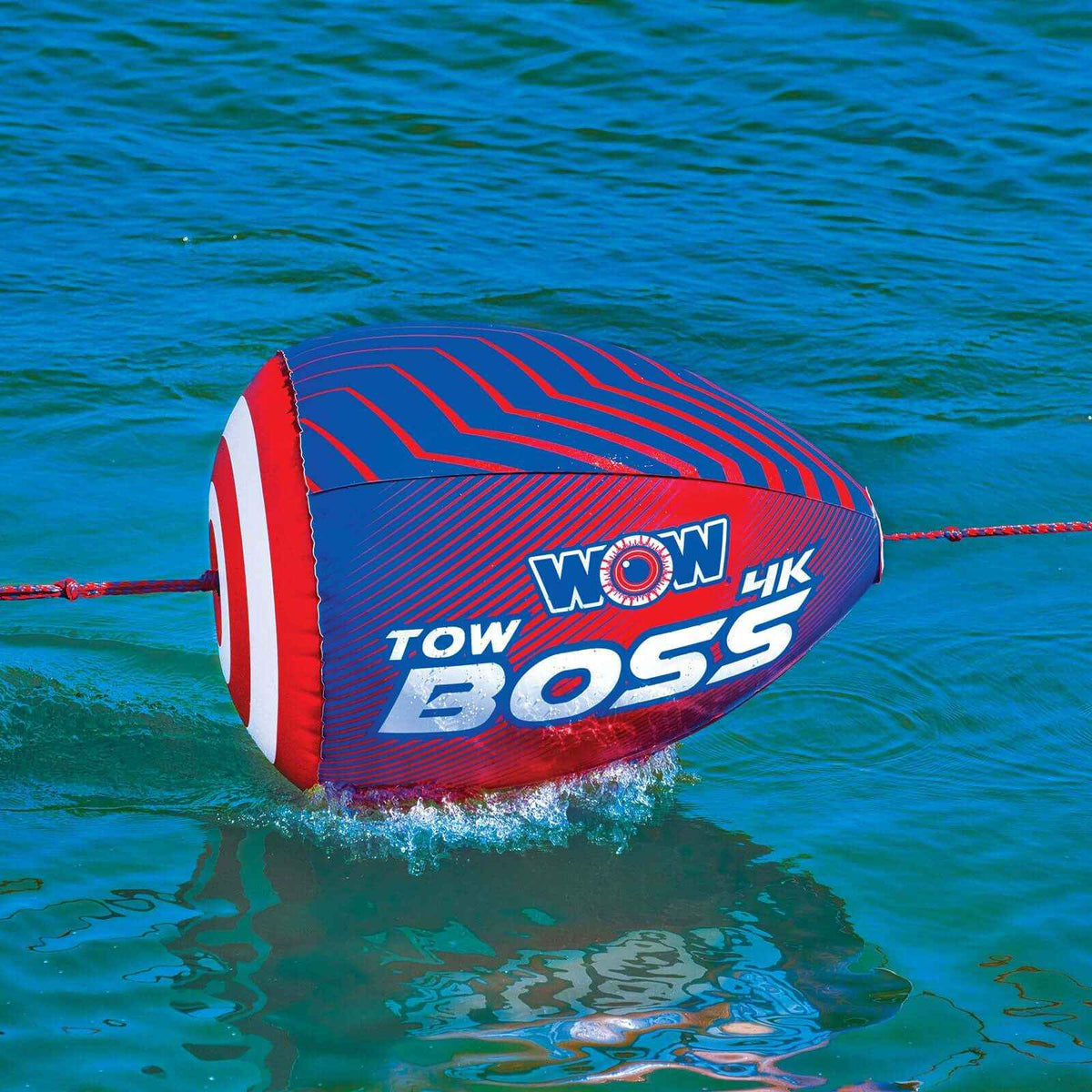 Inflatable WOW Watersports Tow Boss floating on water, showing its bright orange tube design.