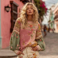Model styling pink long-sleeve crew neck pullover with soft textured knit fabric.