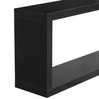 Black square entrance table under a round mirror in a minimalist styled entryway