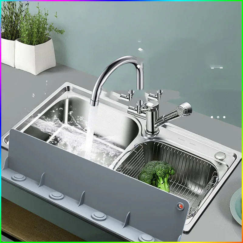 Washing vegetables in kitchen sink with silicone water baffle protecting surrounding counter.