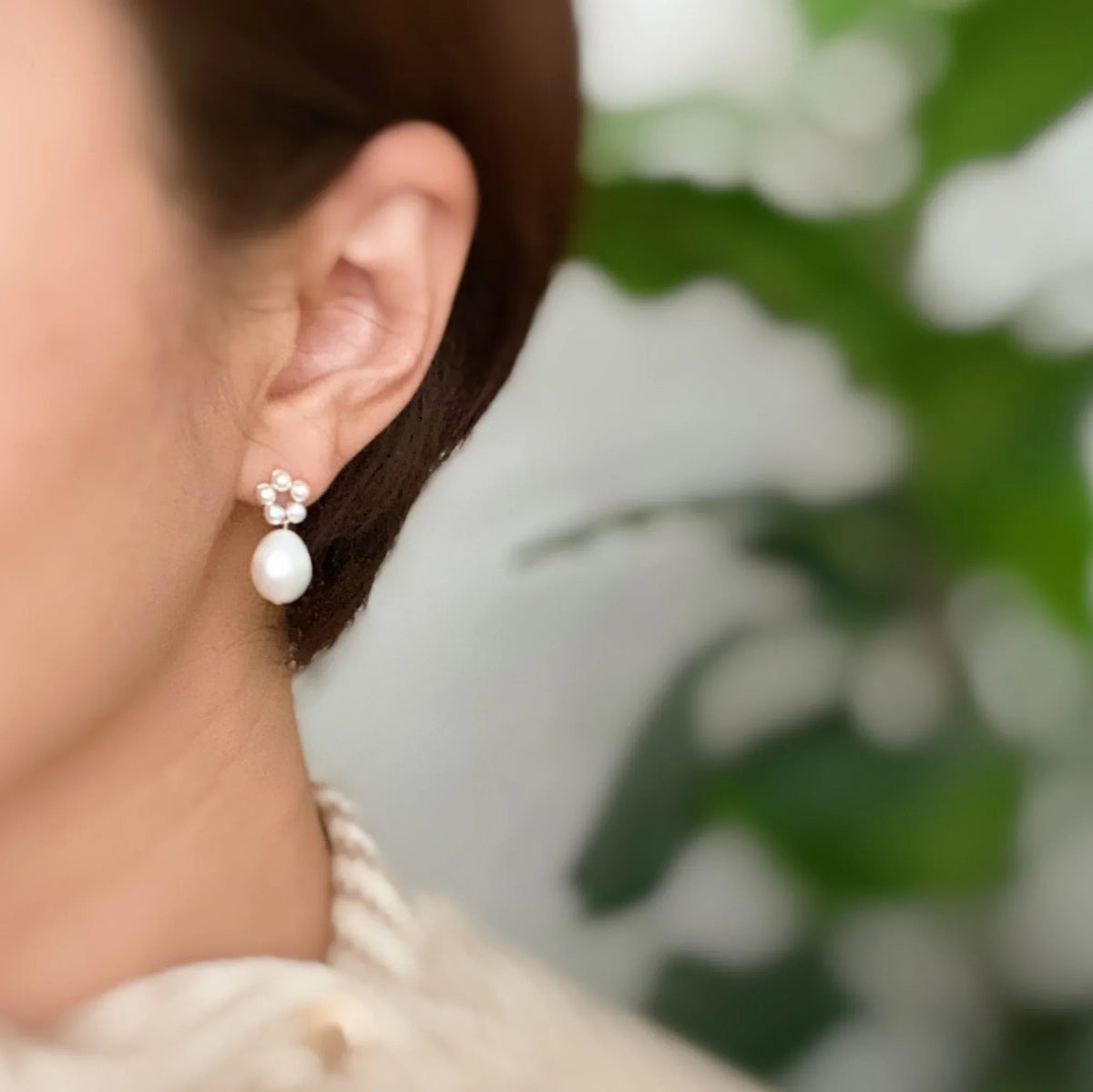 Artistic close-up of pearl earrings highlighting the glazing and texture of the freshwater pearl drops.