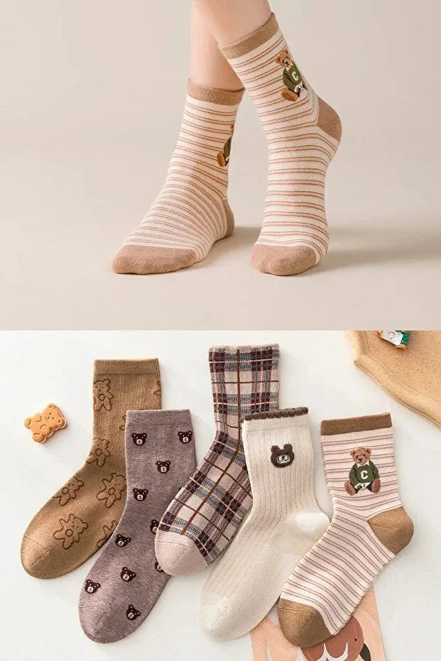 Five pairs of women's patterned socks in various pastel colors laid out flat showing different designs.
