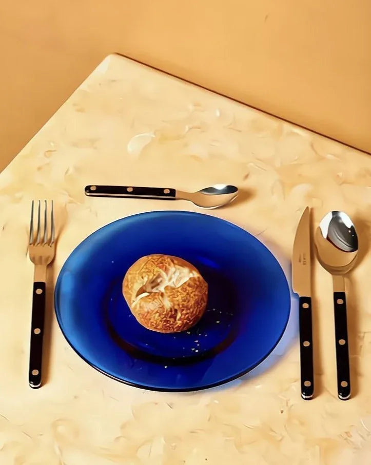 Full set of 8-piece Nordic style flatware in ivory color, neatly organized on a dark textured surface.